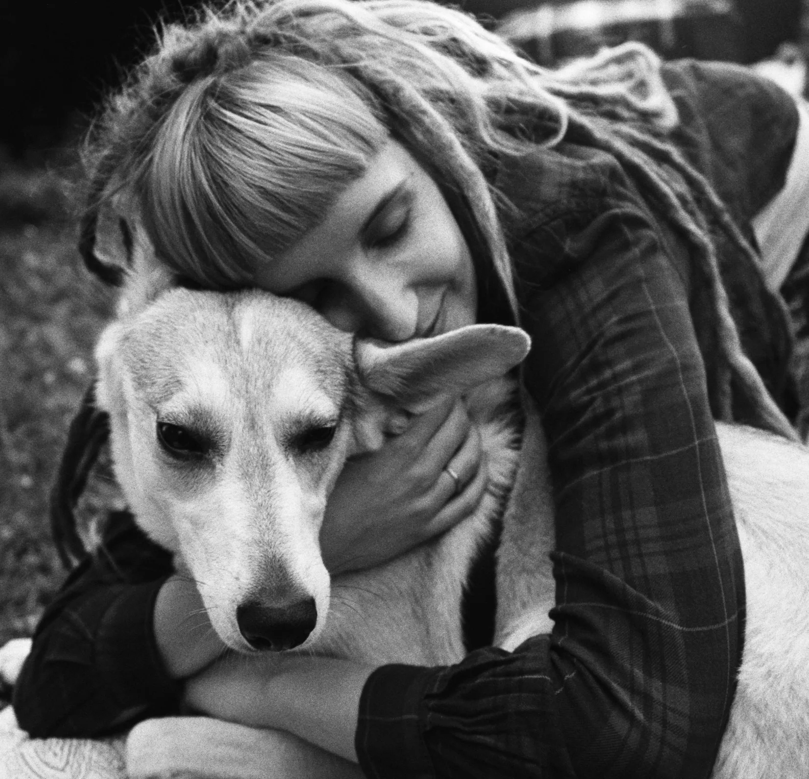 An owner embracing their dog outdoors